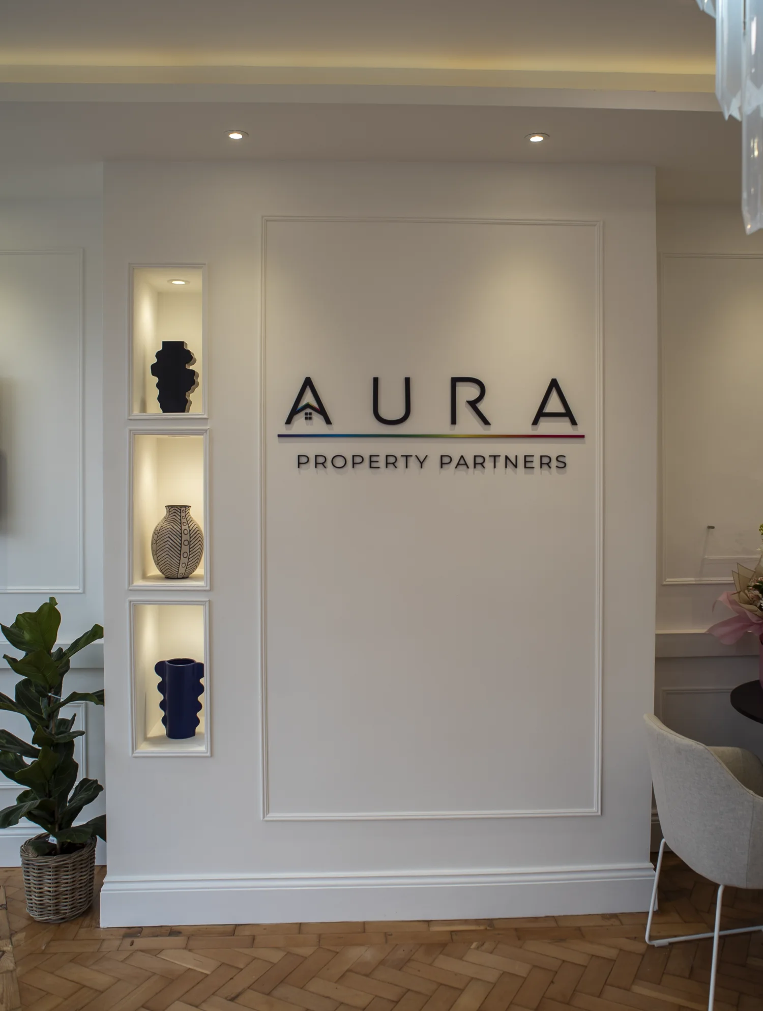 Inside the Aura Property Partners office, showing the reception area and wall signage